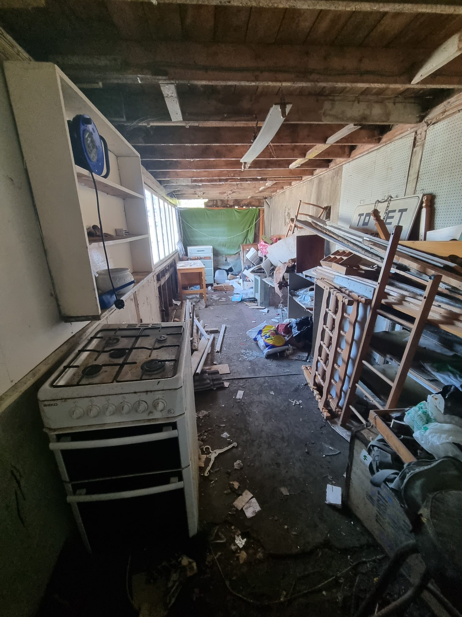 A cluttered shed interior full of old furniture and junk before a Dublin clearance