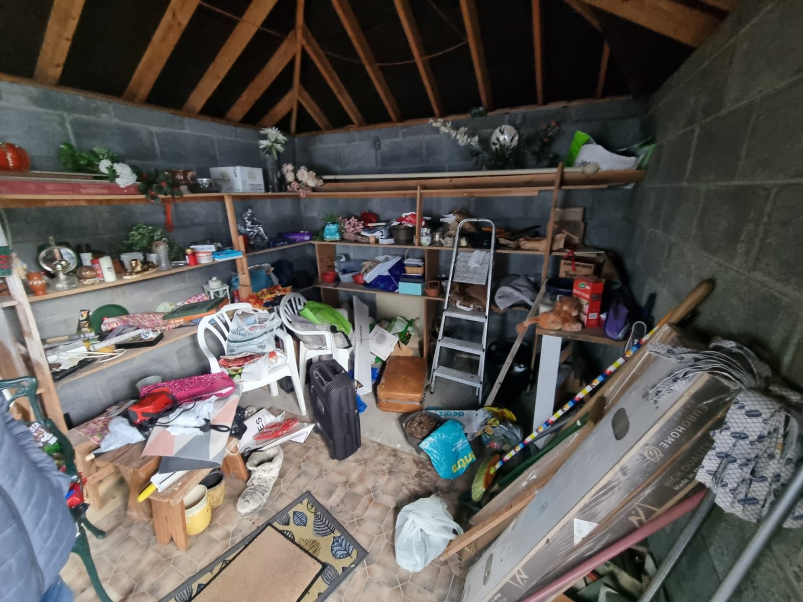A garage lined with shelves of tools, paint and stored household items