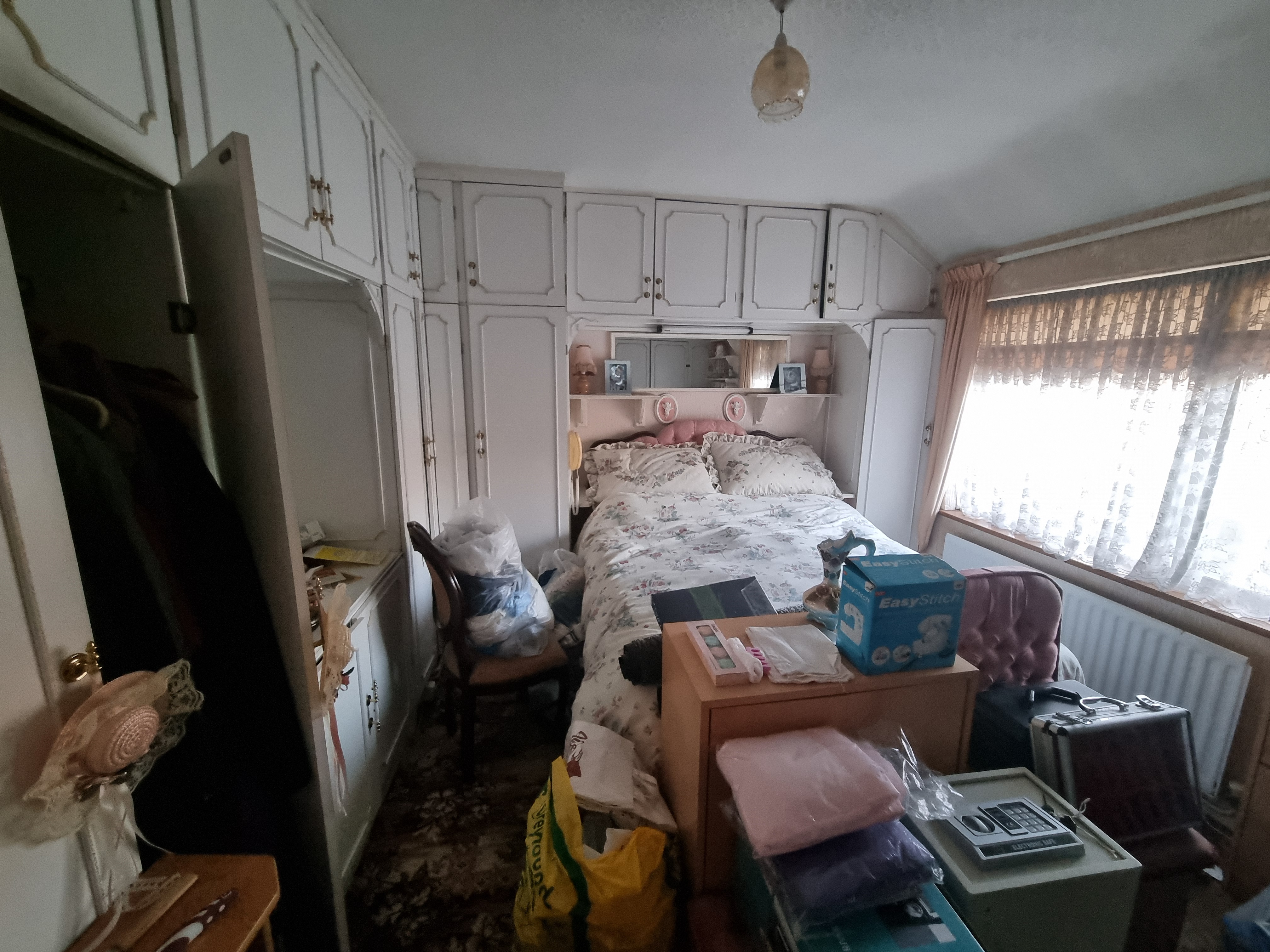 A bedroom with accumulated belongings cleared discreetly