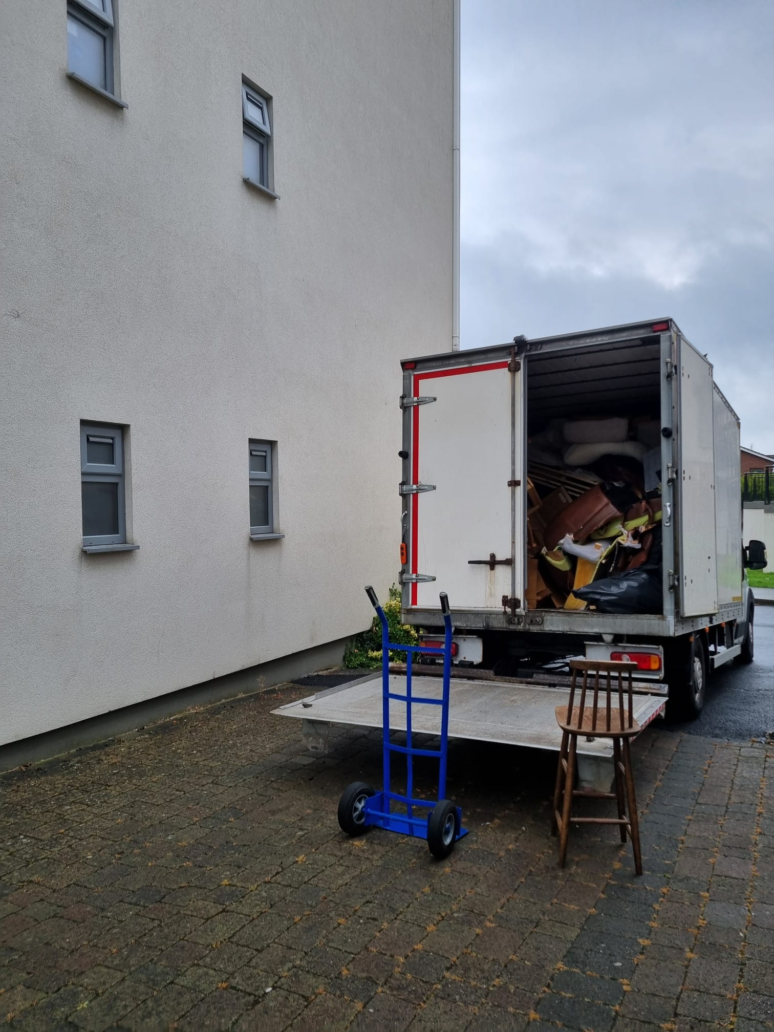 A van loaded with furniture outside an apartment building during a Dublin clearance