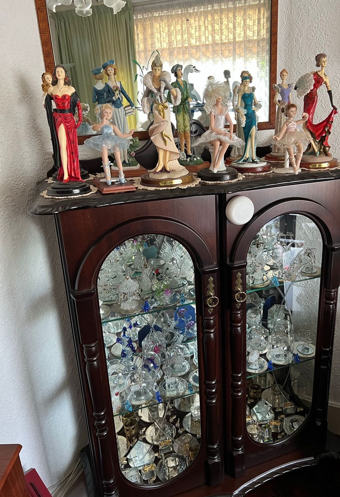 A display cabinet of glassware and porcelain figurines in a family home